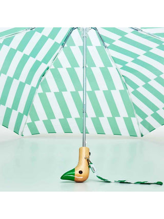 Underside view of a green and white striped umbrella, with the wooden handle being a duck's head with a green beak.