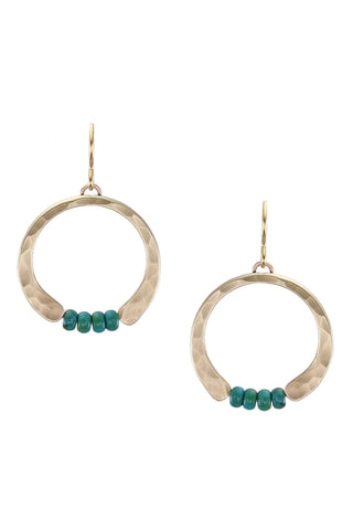 A brass hammered crescent earring completed by four turquoise beads at the bottom.