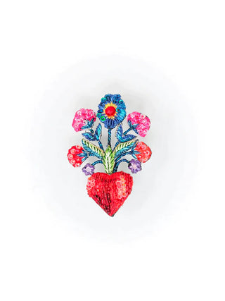 An embroidered brooch of a red heart with colorful flowers sprouting from the top.