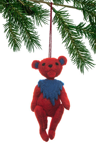 A felt ornament of the Grateful Dead's bear below a Christmas tree branch.