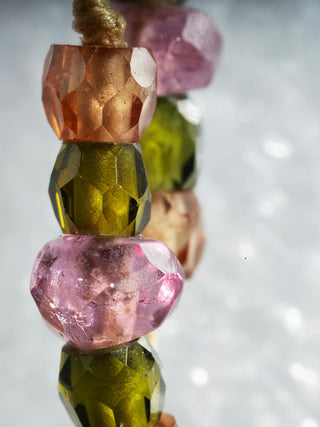 A close-up shot of the micro-macrame knots and pink tourmaline and zirconium beads.