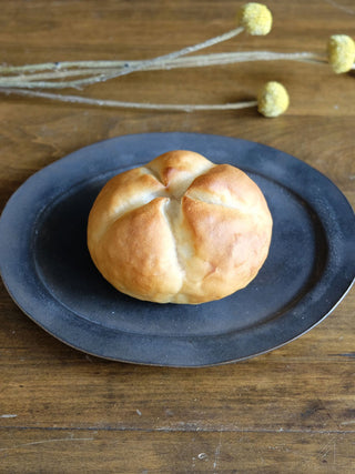 The Kaiser Roll Real Bread Lamp sitting on a plate looks like the real thing.