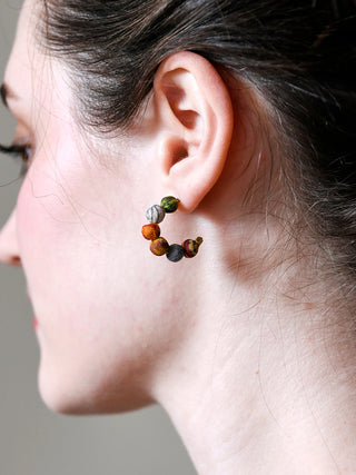 A close-up of a model's ear with the Kantha Tiny Hoop.