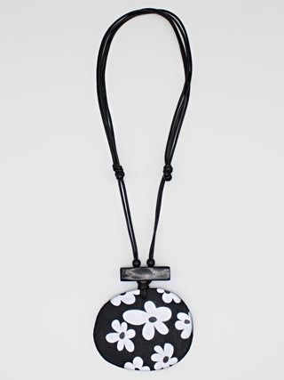 A playful flower design in black and white, on a leather cord.