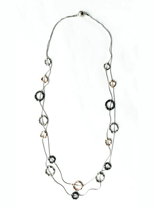 A long seel necklace, flat, with Bronze, Silver, and Slate Circles.