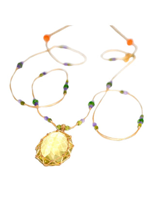 A focused shot of the lemon topaz pendant and the network of knots used to hold it in place.