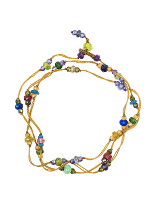 A micro-macrame strand of beads, coiled as a bracelet or anklet.