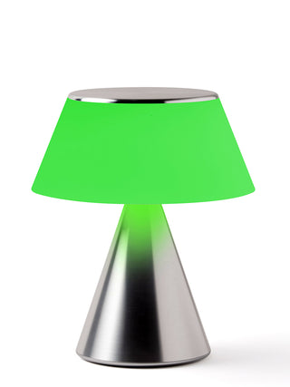 A lamp with a triangular aluminum base and an illuminated  green shade.