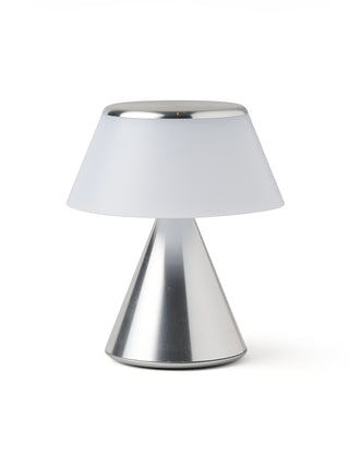A lamp with a triangular aluminum base and an unilluminated  shade.