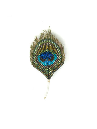 A hand-beaded brooch in the shape of a green and blue peacock feather.