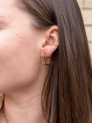 Close-up of a model wearing the gold Luxe Kamora Hoops.