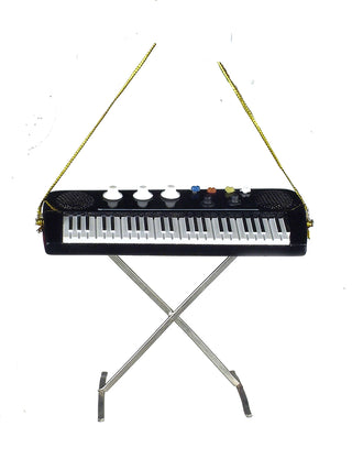An ornament in the form of a black electric keyboard, with a gold cord for hanging.