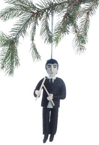 A felt ornament of young Ringo Starr holding drumsticks, hanging from a holiday tree.