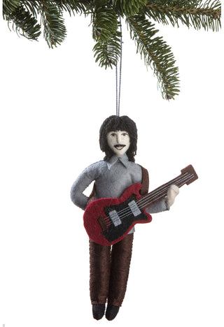 A felt ornament depicting a smiling George Harrison playing a guitar, hanging from a holiday tree branch.