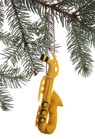 A saxophone ornament made of gold felt, hanging from the branch of a Christmas tree.