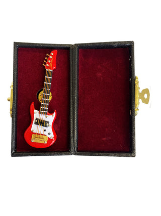 A lapel pin that looks like a red electric guitar, in a red, velvet-lined case.