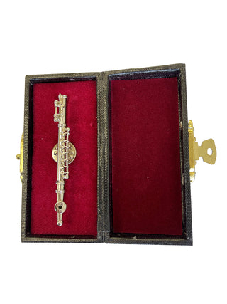 A lapel pin that looks like a silver flute, in a red, velvet-lined case.