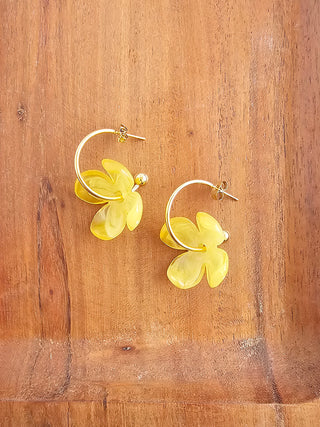 A pair of gold open hoop earrings with a yellow four-petal acrylic flower on each.