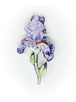 An embroidered, beaded brooch in the form of a purple bearded iris with a green stem.