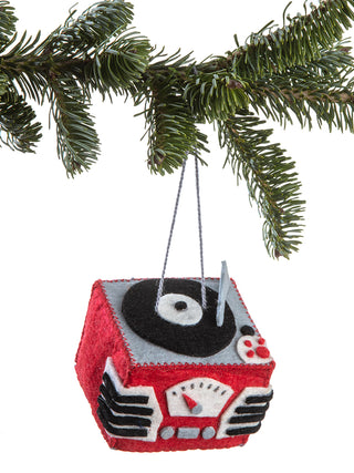 A red felt record player ornament hanging on a Christmas tree.