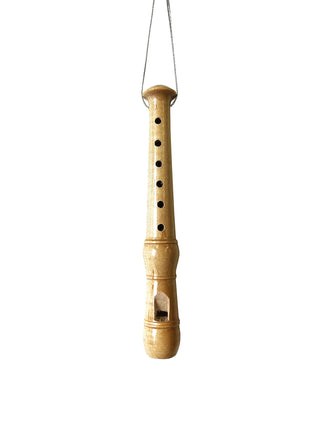 A wood recorder ornament hanging on string.
