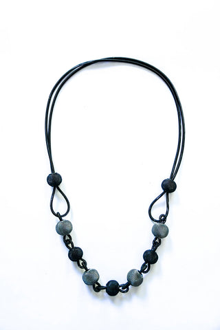 A Long Piano Wire Necklace with Black and Silver Mesh Spheres.