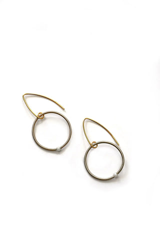 Champagne colored loop earrings made of piano wire, each with a small moonstone bead.