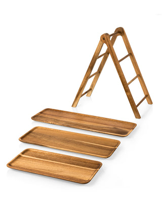 Three wooden trays of varying size in front of a small wooden ladder.