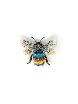 An embroidered brooch in the form of a blue and yellow bee.