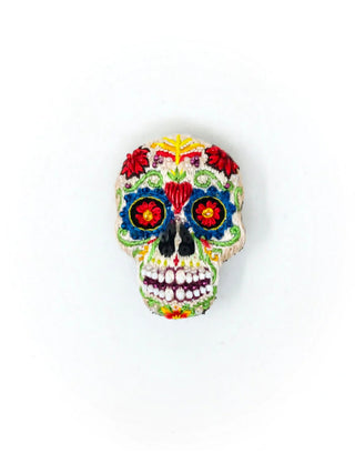 An embroidered, beaded brooch of a colorful skull.