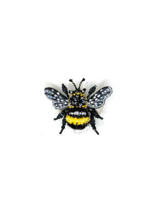 A beaded brooch pin in the shape of a yellow-banded bee on a white background.