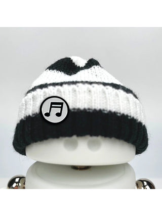 A Marmal figure wearing a black and white beanie with a music note pin.