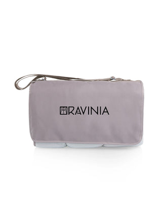 A beige blanket tote, rolled, with a carrying strap and the Ravinia logo on the front.