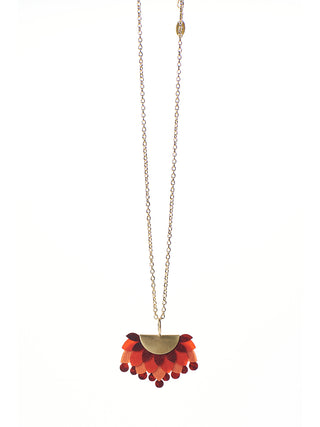 A brass chain necklace with a red and gold pendant made of drum leather.