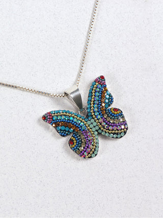 A bedazzled pendant in the shape of a butterfly on a silver chain.