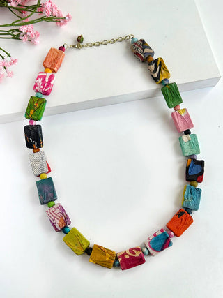 A necklace made of rectangular wooden beads wrapped in sari fabrics.