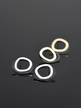 One pair of gold and black ear jacket earrings, and one pair of silver and black ear jacket earrings, all on a black background.