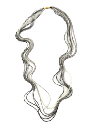A black, silver, and ivory colored multi-strand pleated fabric necklace.