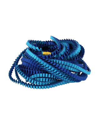 A royal blue and turquoise colored multi-strand pleated fabric necklace, coiled.