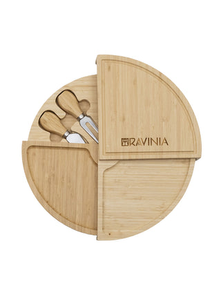 A circular multi-tiered bamboo cheese board with cheese tools.