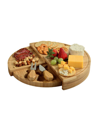 A multi-tiered wooden cheese board with cheese, fruit, and crackers.