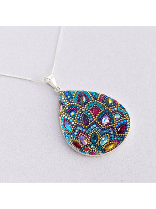 A bedazzled teardrop pendant on a silver chain.