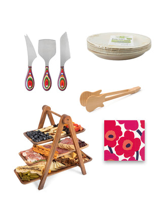 A serving ladder, a three piece set of cheese knives, a palm leaf plate, a pair of tongs, and red poppy napkins, all on a white background.