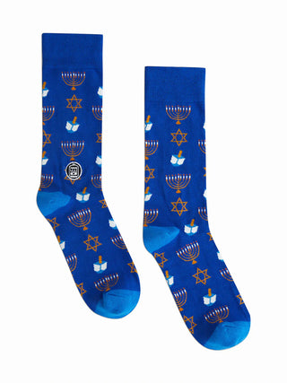 A pair of blue socks with gold details of menorahs, the Star of David, and dreidels.
