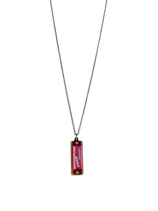 A red harmonica on an aged-brass chain.