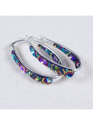 A pair of silver hoop earrings with colorful crystals on the inside and outside of the hoop.
