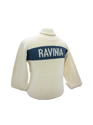 A natural colored knit sweater with a roll neck and a blue stripe with the word Ravinia.