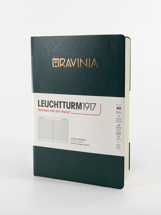 A dark green hardcover notebook from Leuchtturm1917 with the Ravinia logo in copper foil.