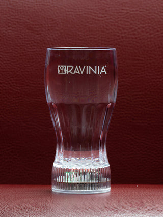 A clear plastic glass with the Ravinia logo, on a red background.