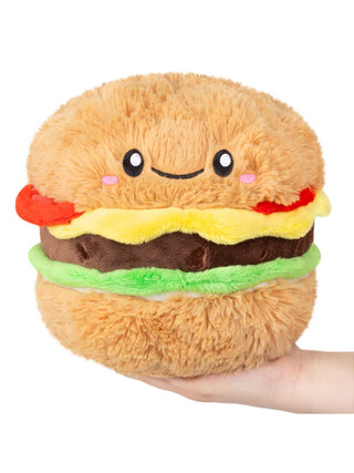 A smiling plush cheeseburger sitting on a hand.